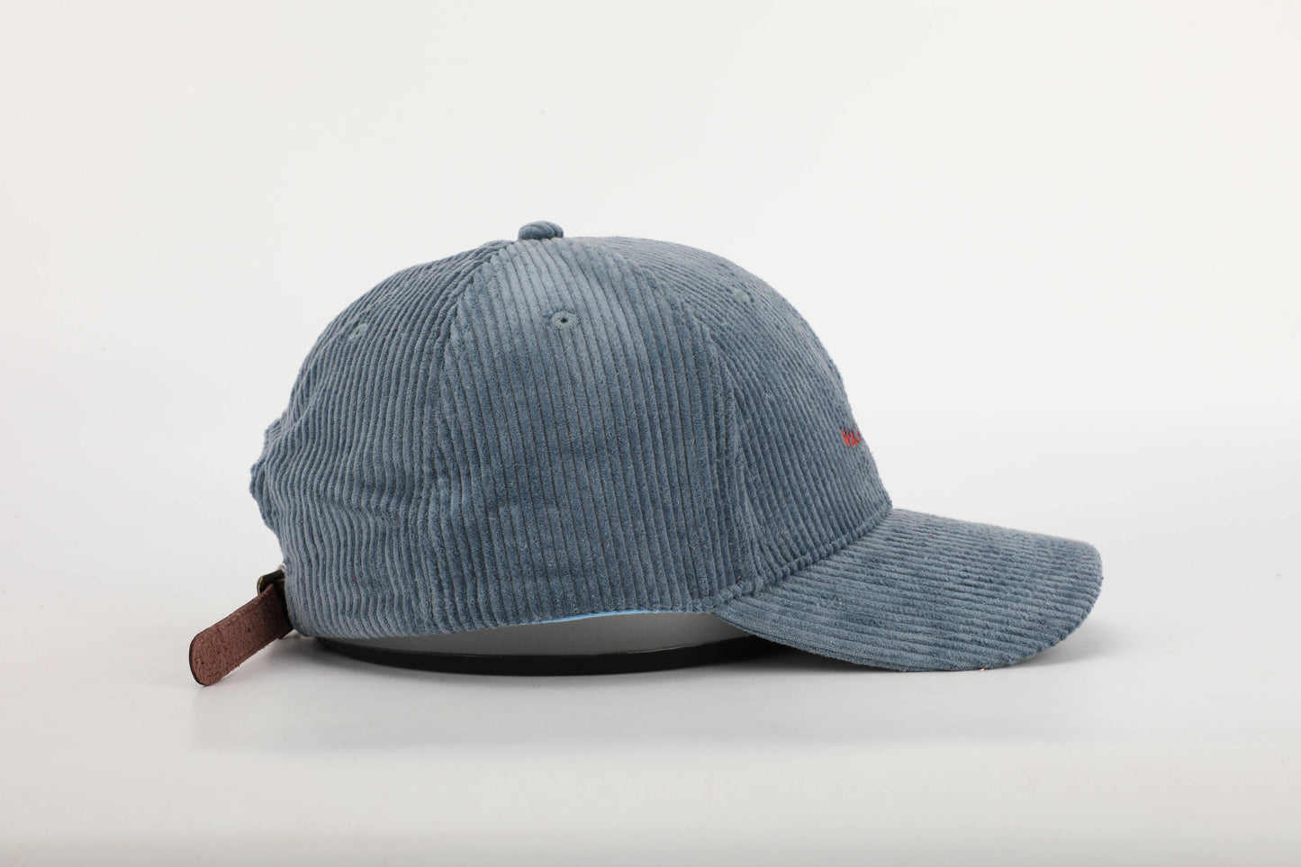 unisex blue corduroy cap orange stitching brown leather buckle strap baseball cap side on